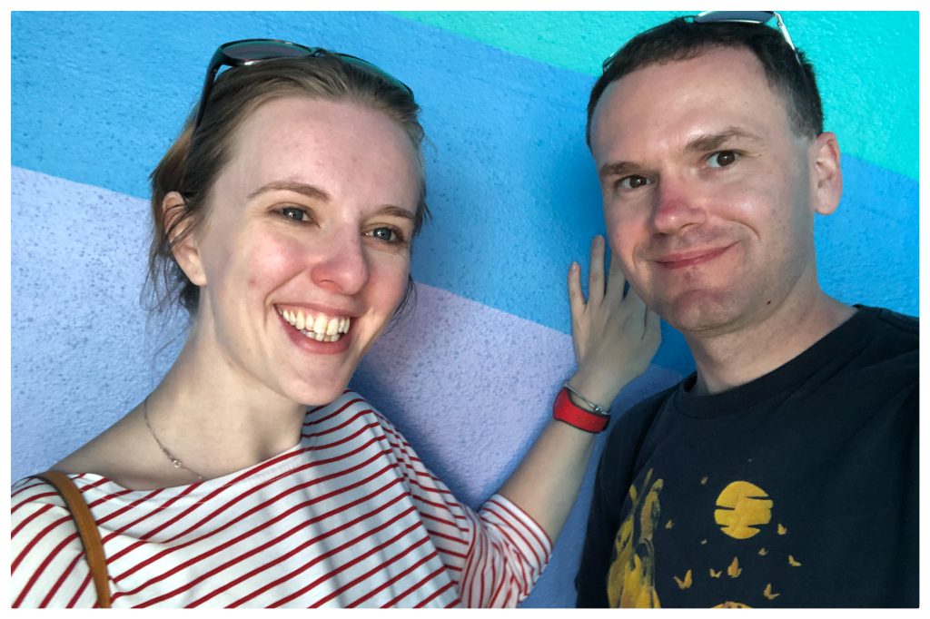 Fiona and Alistair standing in front of the Toothpaste Wall at EPCOT.