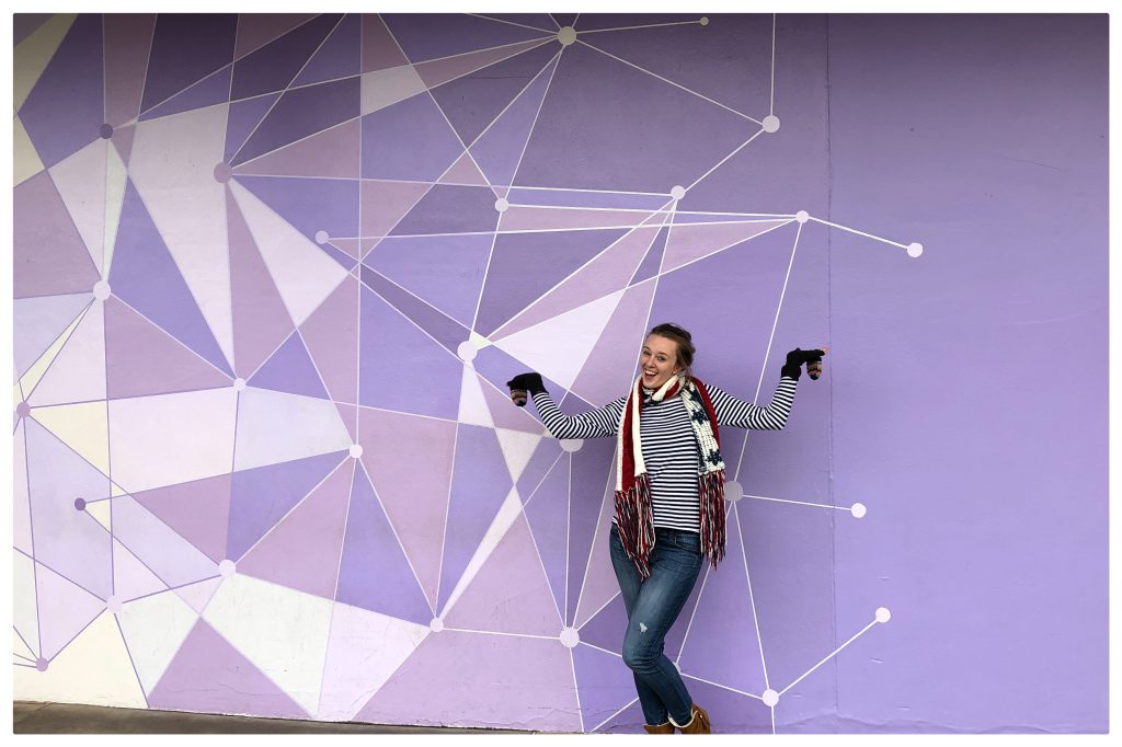 Fiona standing in front of Walt Disney Worlds Magic Kingdom Purple Wall